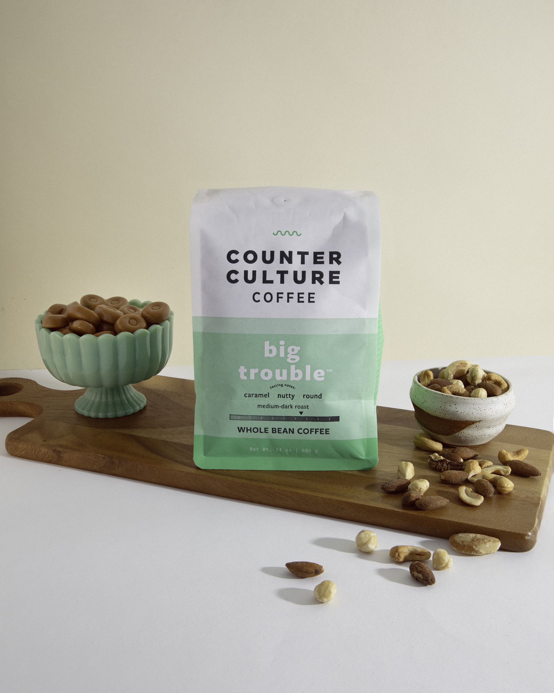 Counter Culture Coffee 'Big Trouble' bag with pistachios on a wooden board.