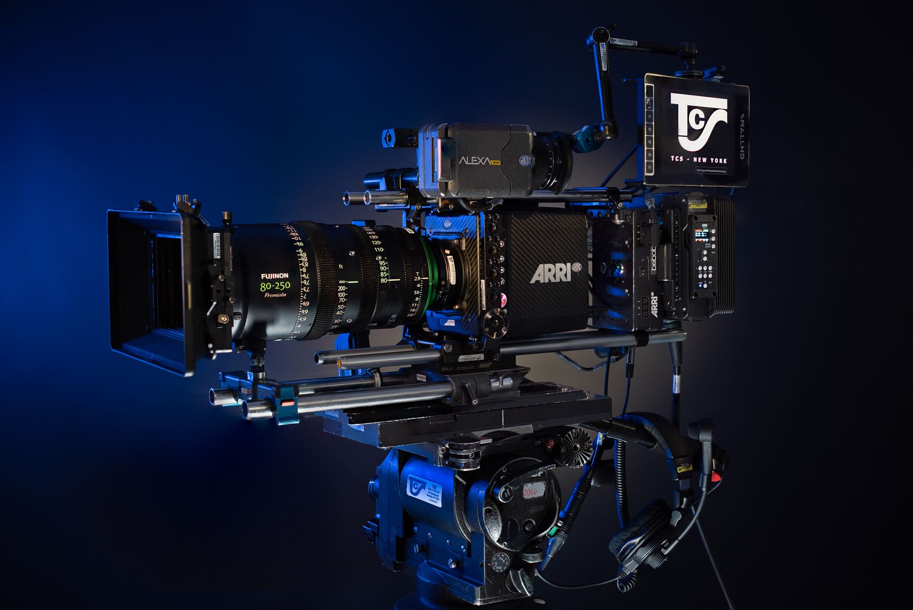 Cinema camera build with zoom lens and TCS-branded monitor, blue rim light.