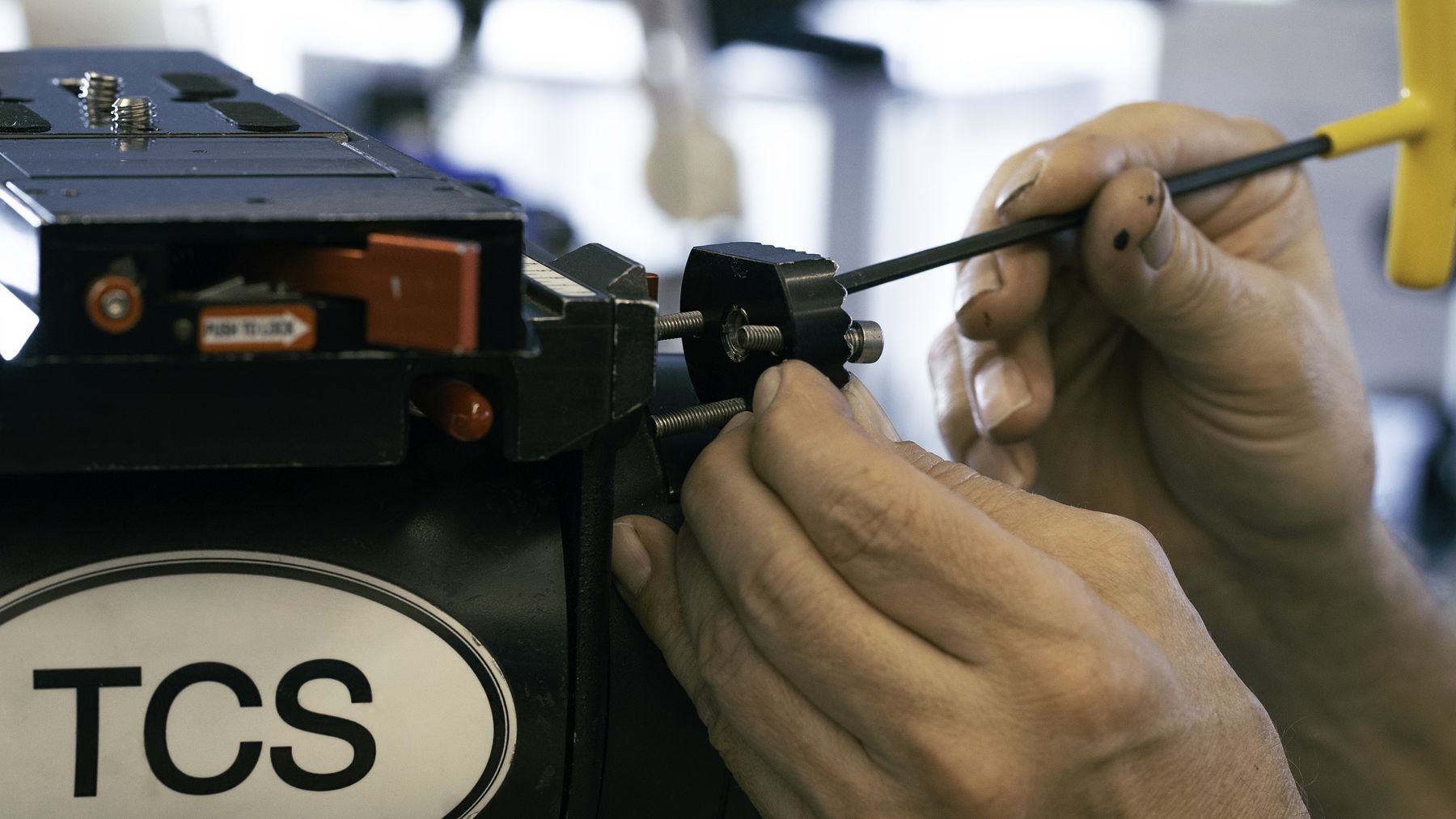 Technician working on a TCS-labelled camera body.